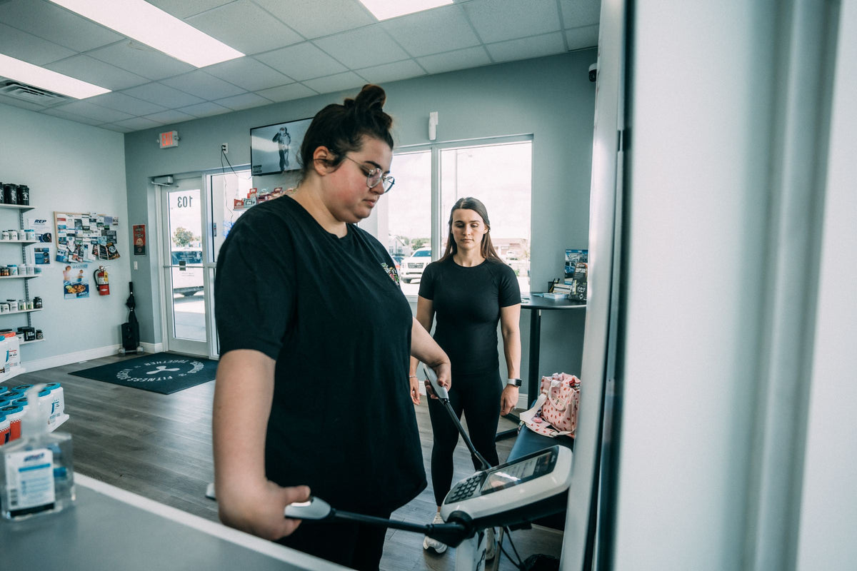 Client stepping on the InBody body composition scanner with a coach