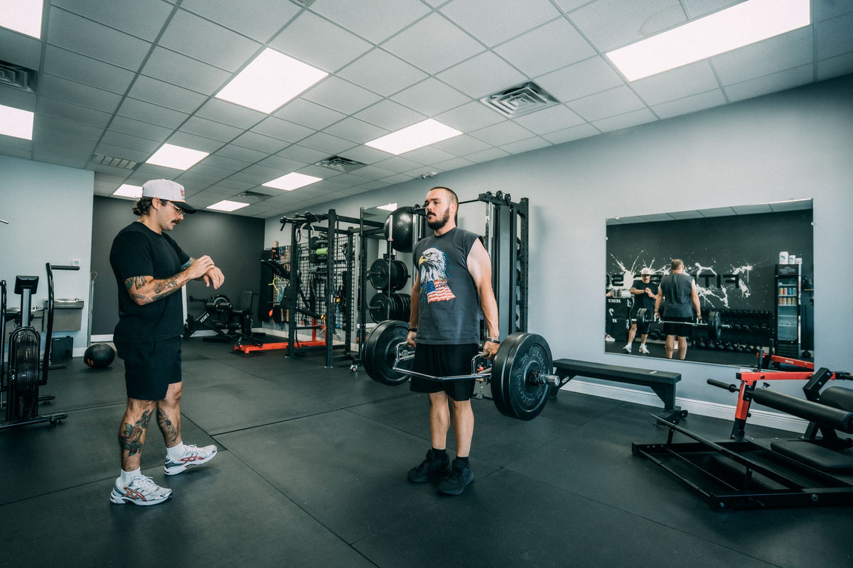 Coach cueing a client through a barbell deadlift at Fitness Society Coaching in Melbourne, FL