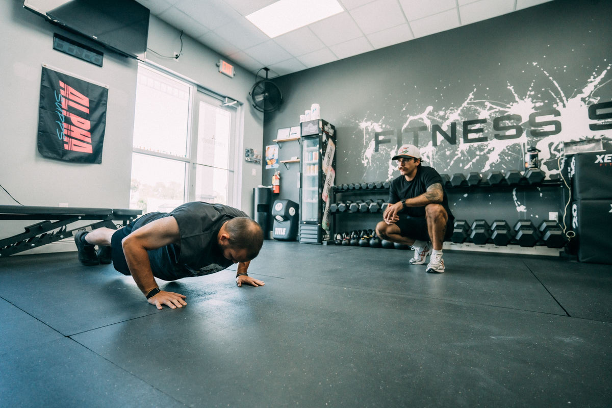 Push-up coaching in front of the Fitness Society wall