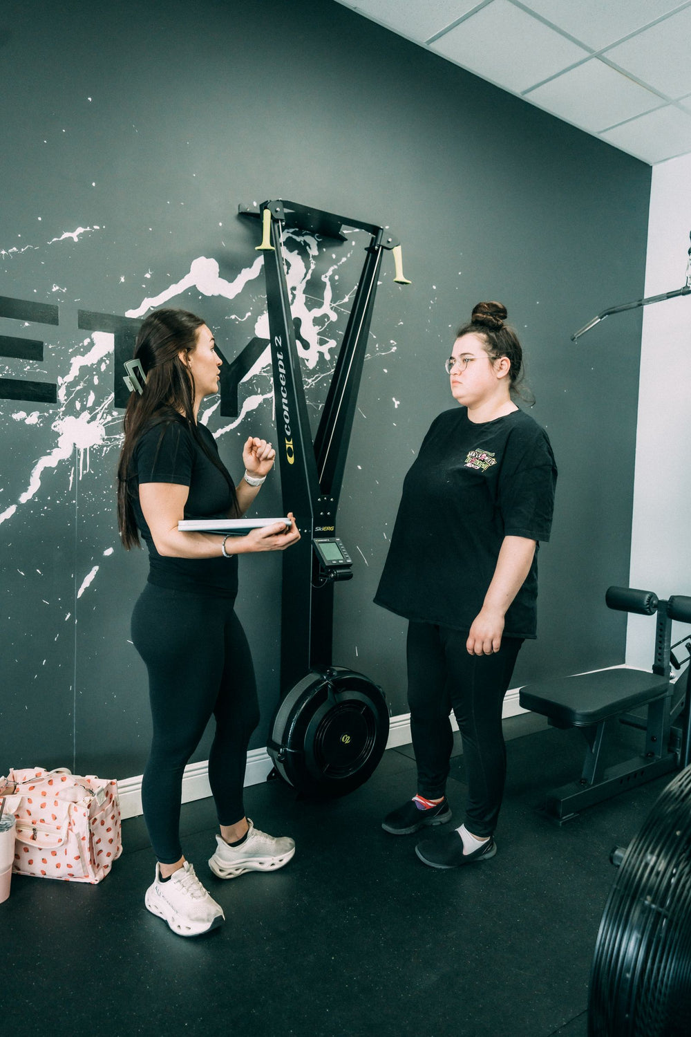 Coach and client planning a session beside the ski erg