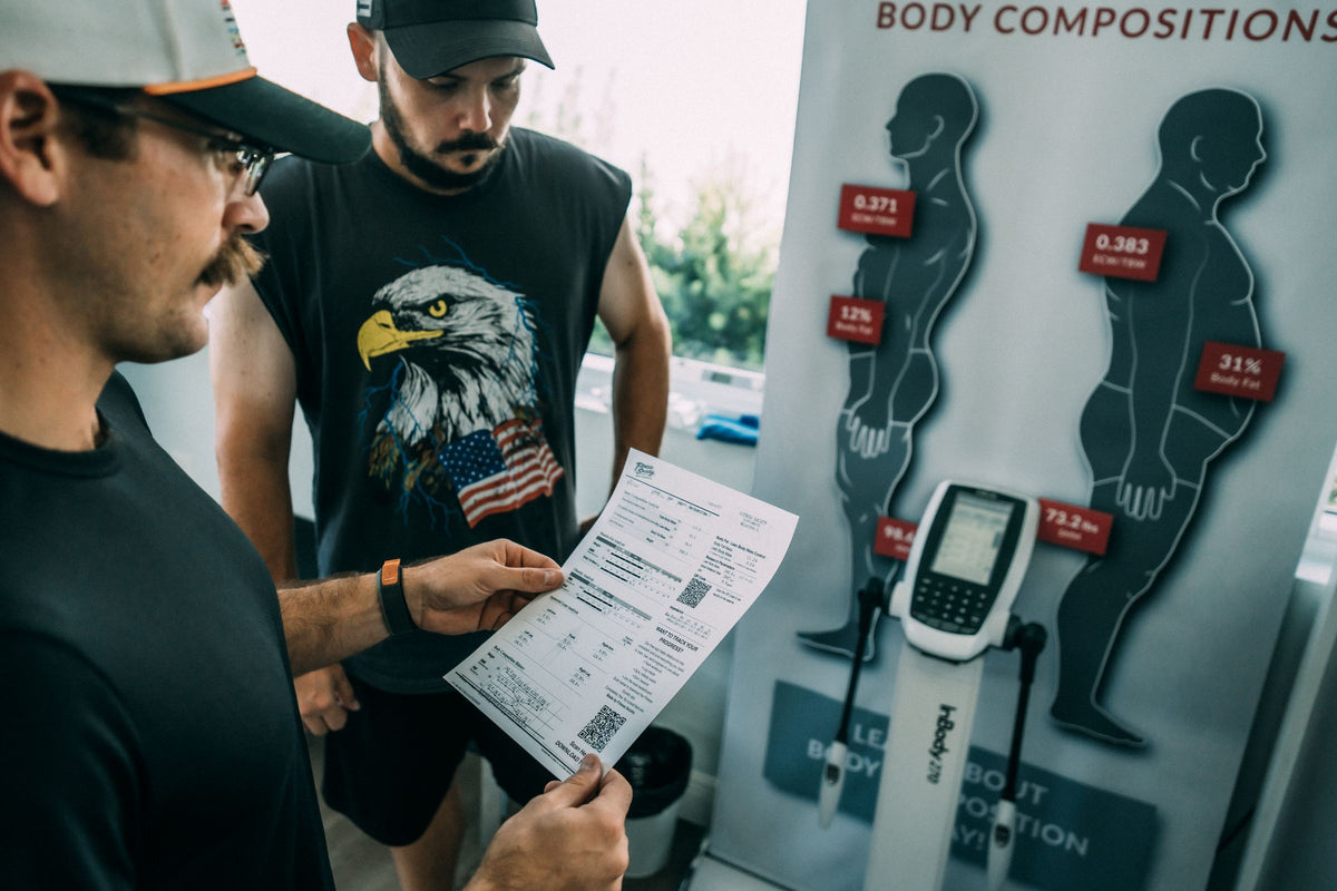 Coach walking a client through InBody results next to the scanner