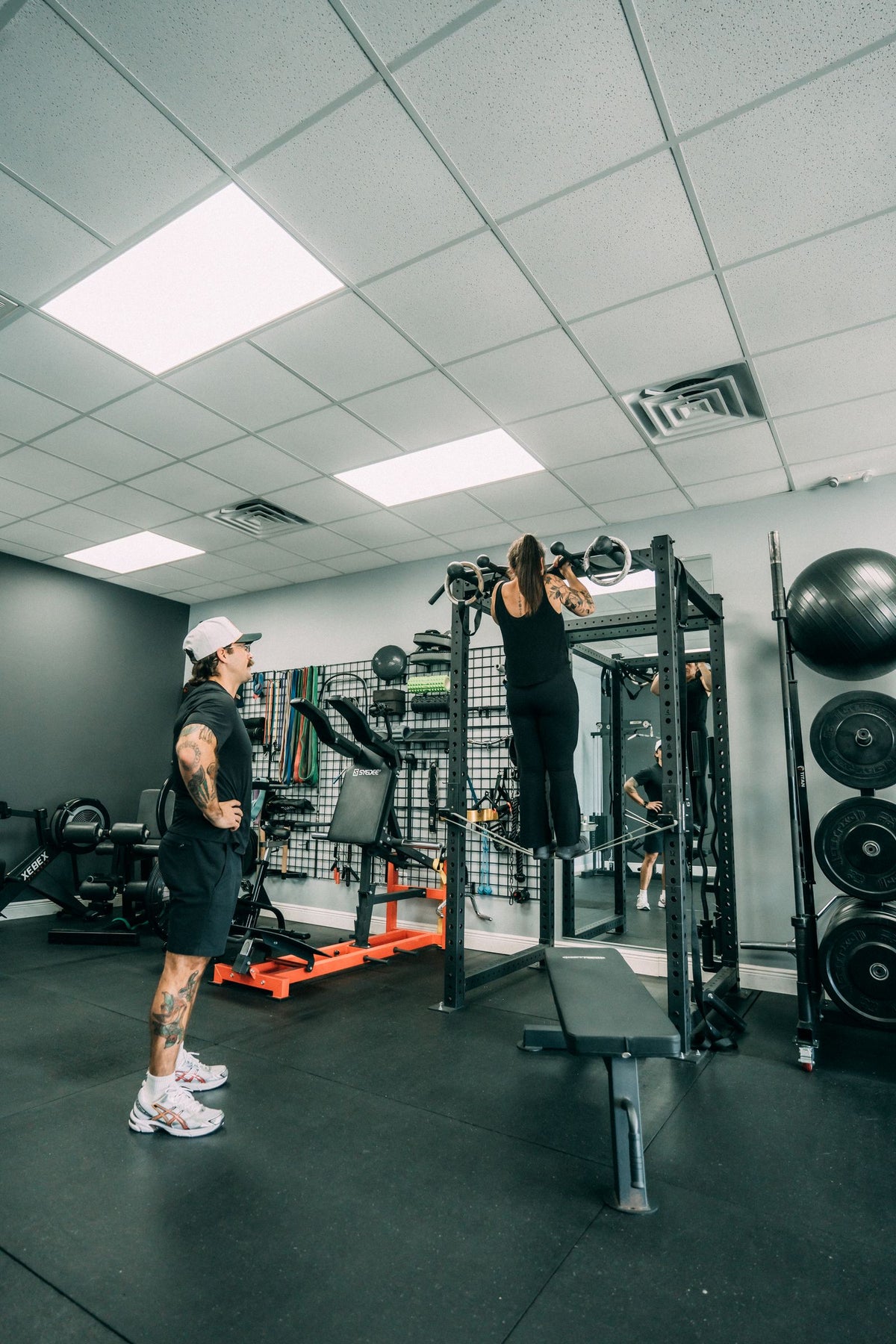 Coach supervising an overhead press in the private studio